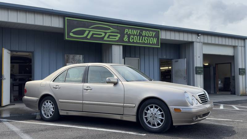 Champagne Mercedes sedan parked in front of the JPB Paint Body & Collision shop