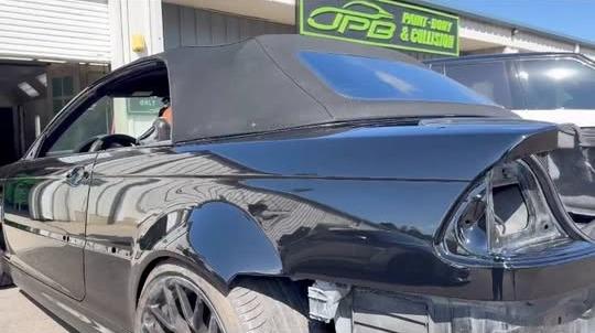 Black convertible with its taillights removed during rear-end repair outside the JPB shop