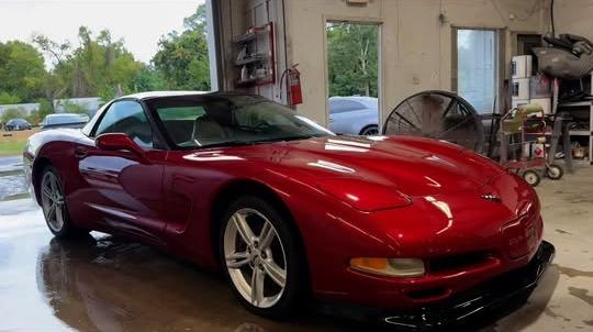 Red Corvette with fresh paint inside the shop bay